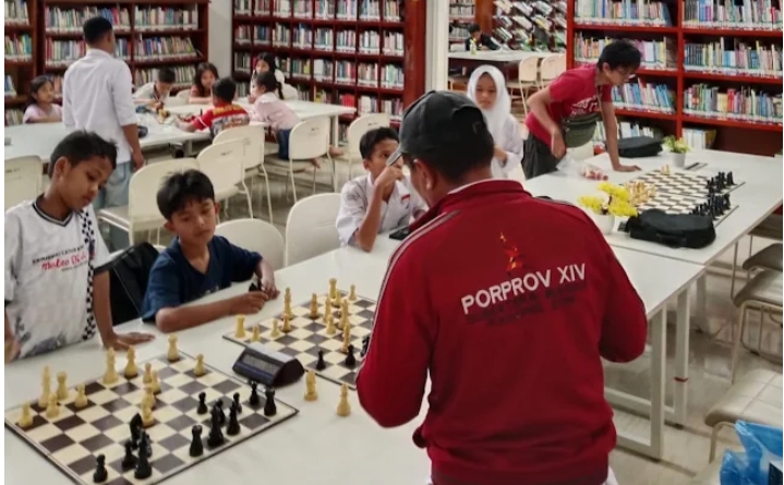 Pelatih senior dan anak-anak tampak antusias saat sesi latihan catur dalam persiapan menuju ajang Porprov XIV, bertempat di perpustakaan kota. (foto/istimewa)